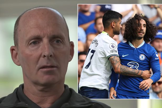 Mike Dean on the left and two football players on the right