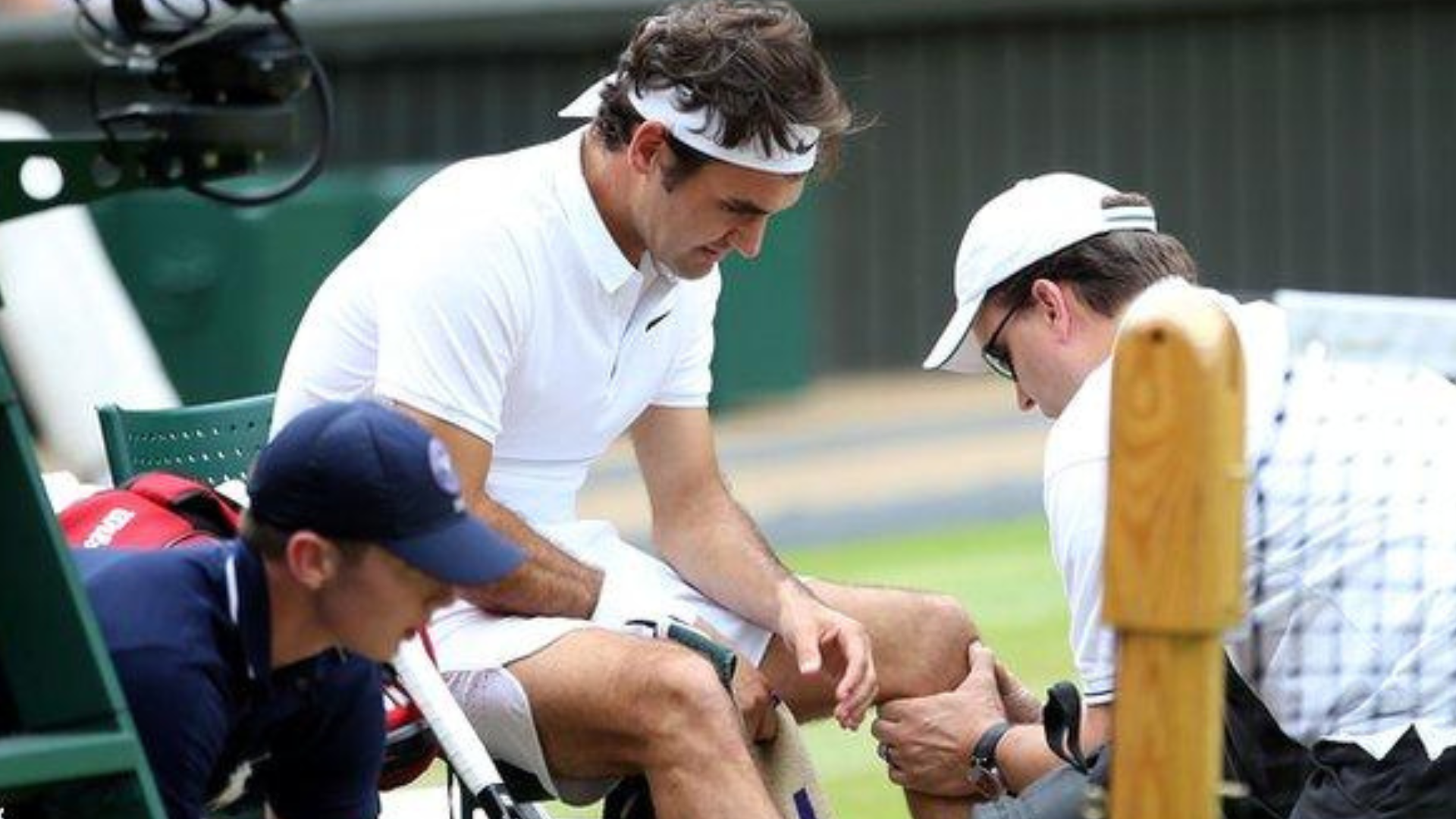 Roger sitting down with someone holding his knee