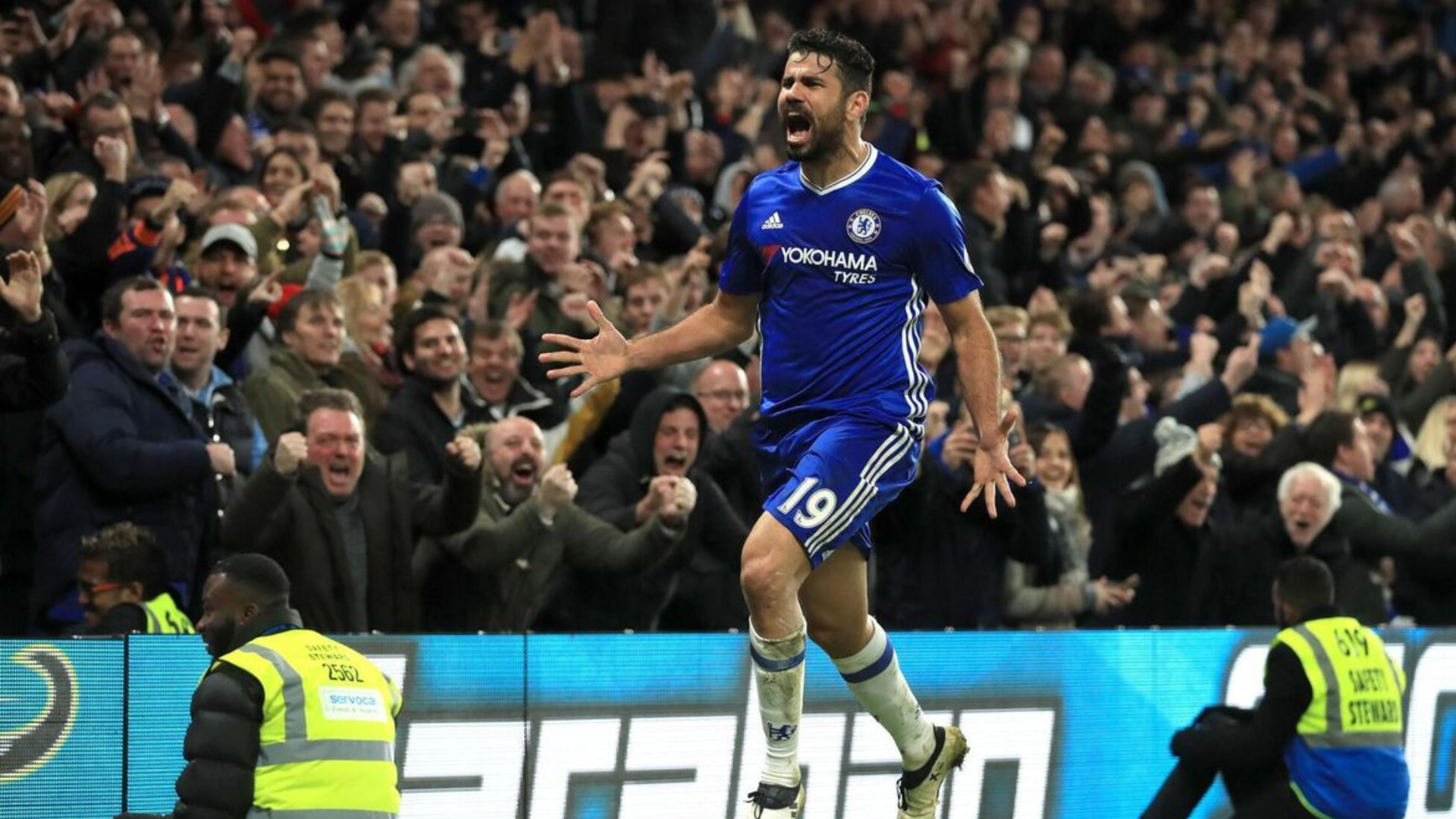 Diego costa shouting while running with a big crowd around him