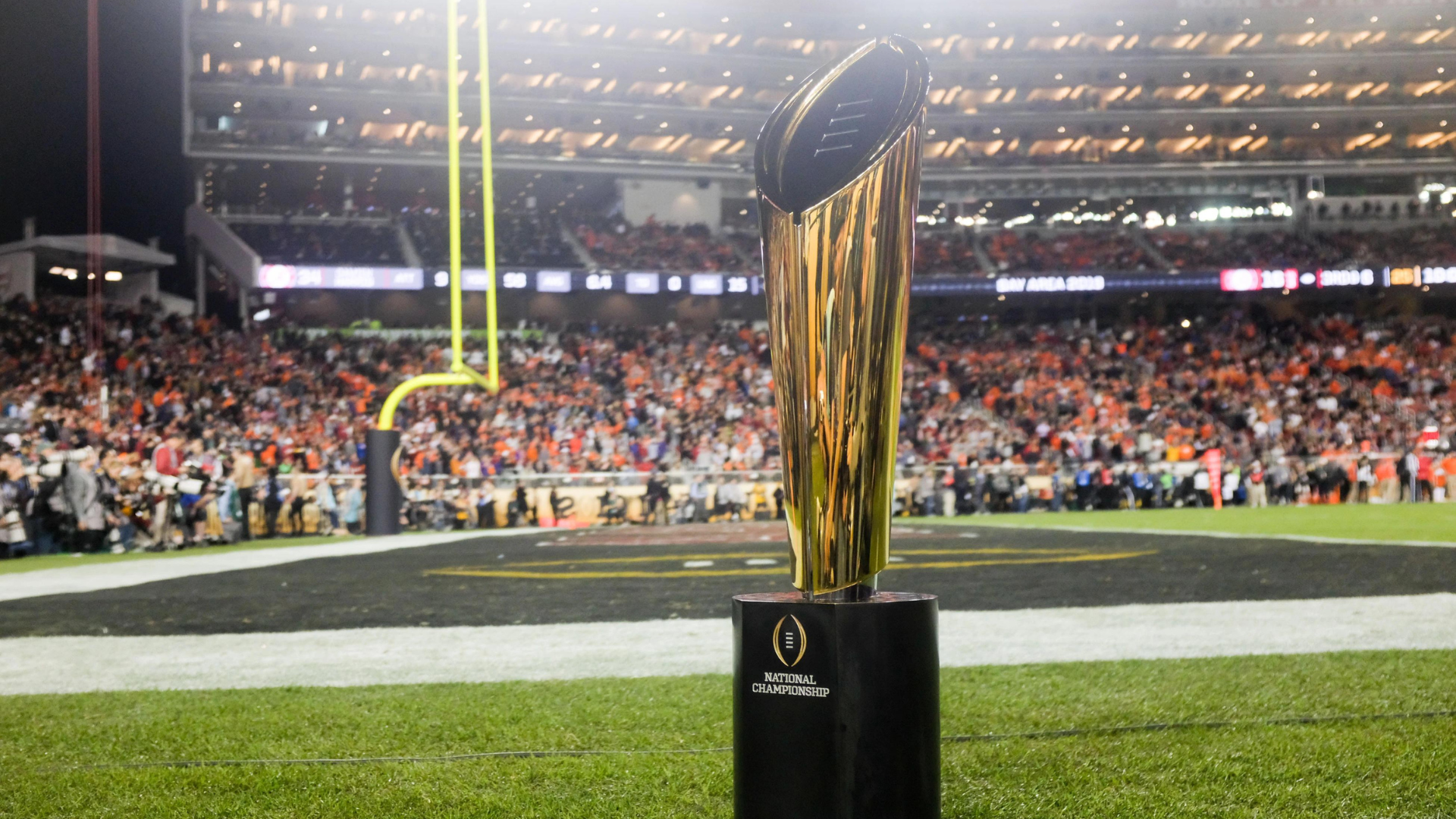 A national championship trophy placed on the field with big crowd around it
