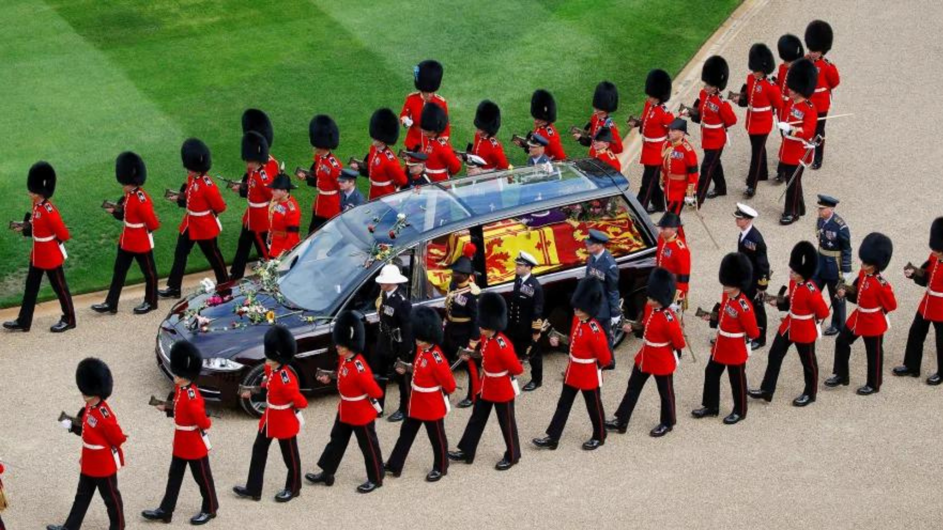 Palace guard marching with a black car with thq queen's casket