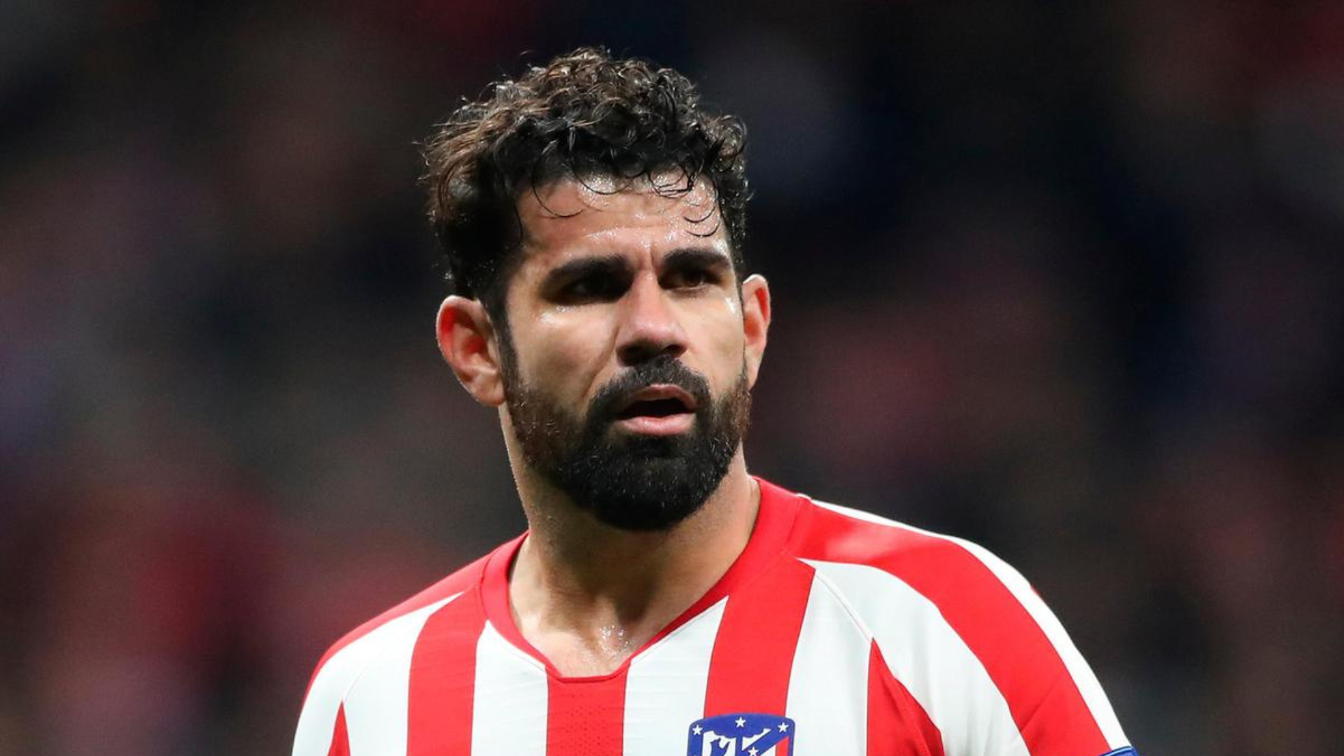 Diego Costa with beard and wearing red and white soccer uniform