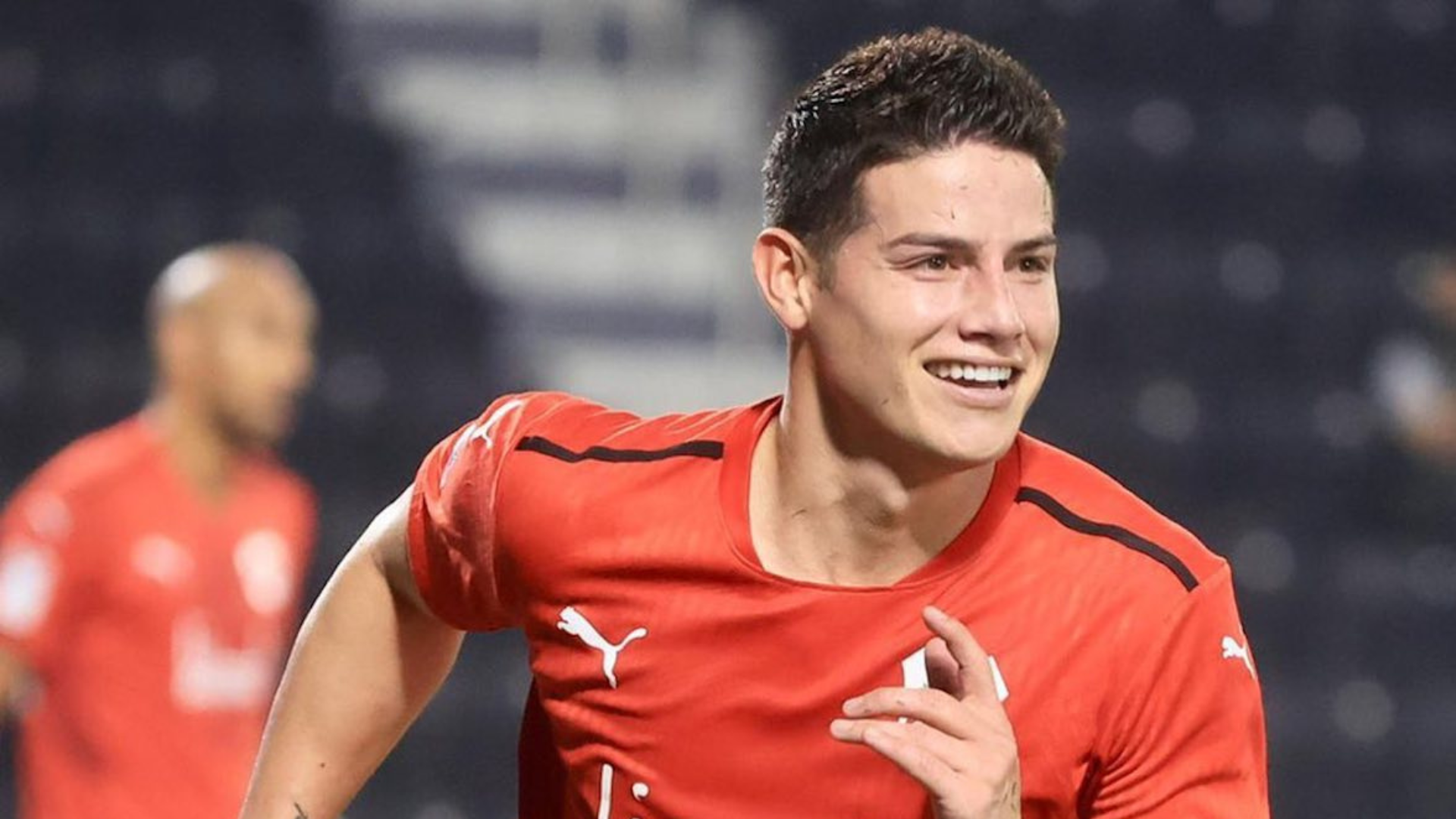 James Rodríguez wearing red uniform and smiling while running