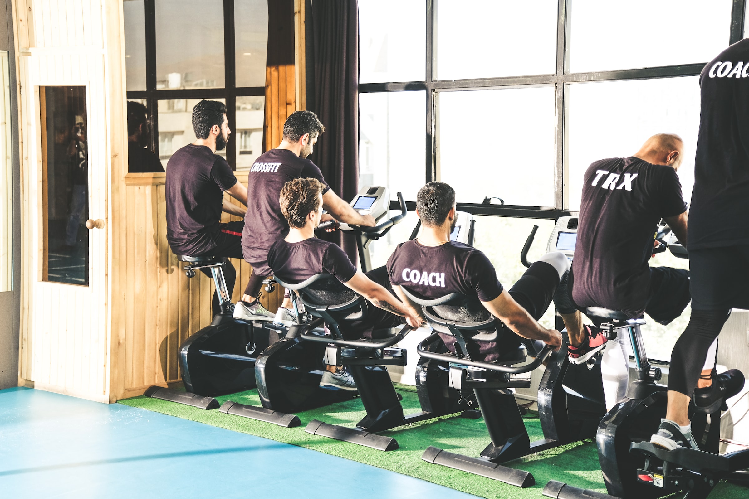 Men in stationary bikes working out
