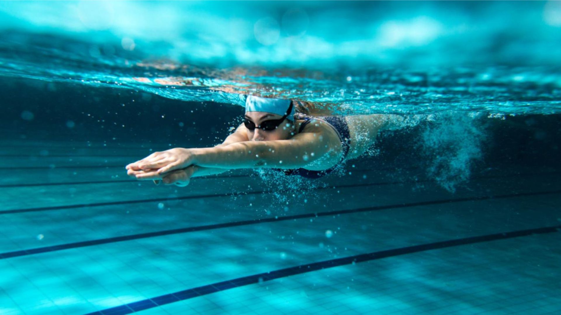 Woman Swimming Wearing Googles Underwater