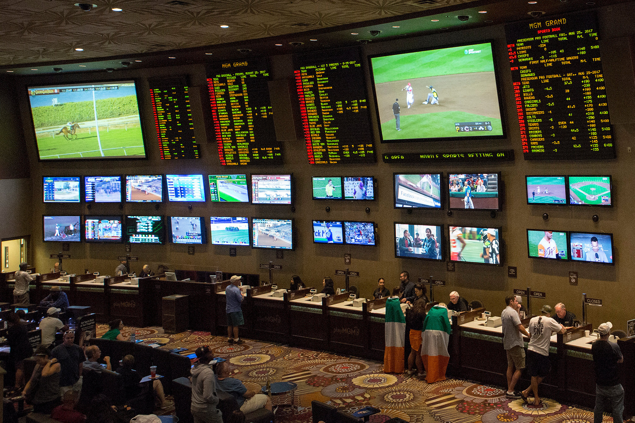 A lot of screens in front of a crowd of bettors