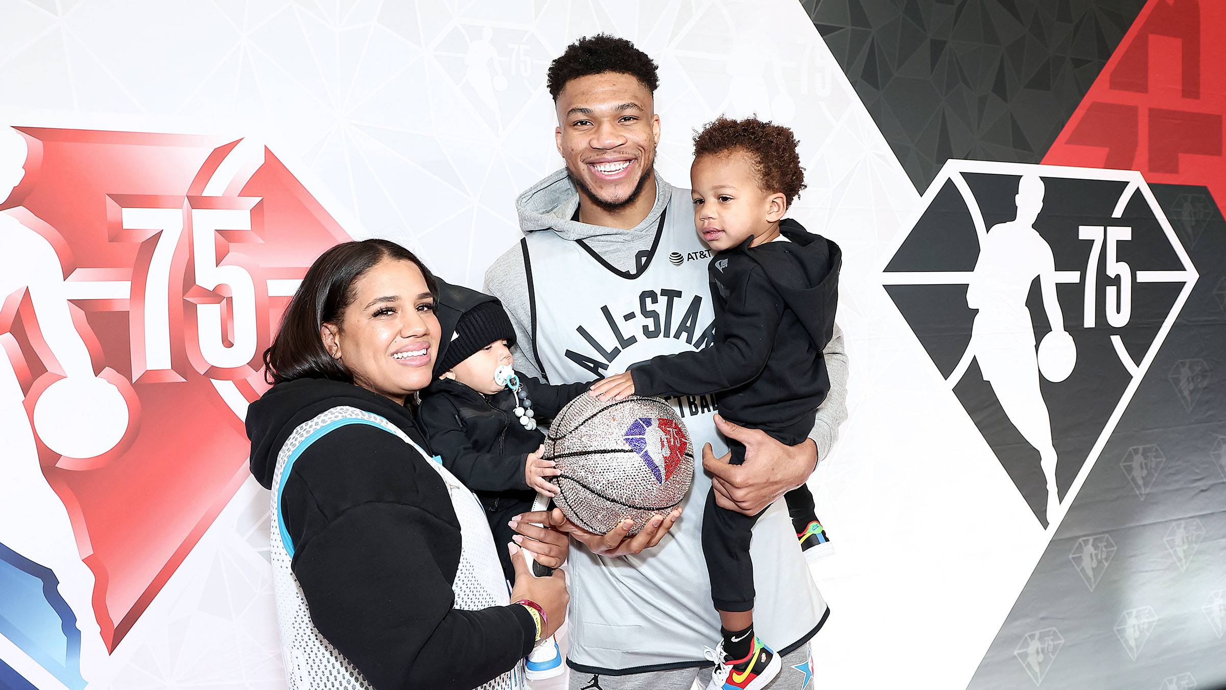 Mariah Riddlesprigger And Giannis Antetokounmpo Holding their Children with a bedazzled basketball